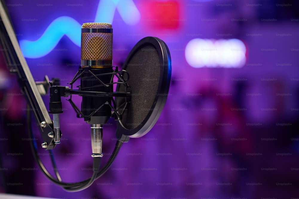 Toma horizontal sin enfoque selectivo del micrófono con filtro de pop de disco en un estudio de grabación moderno