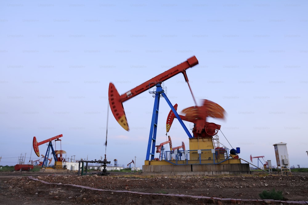 Oil field site, in the evening, oil pumps are running