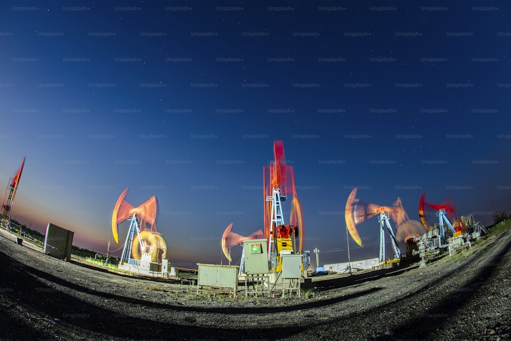 Local do campo de petróleo, à noite, as bombas de petróleo estão funcionando