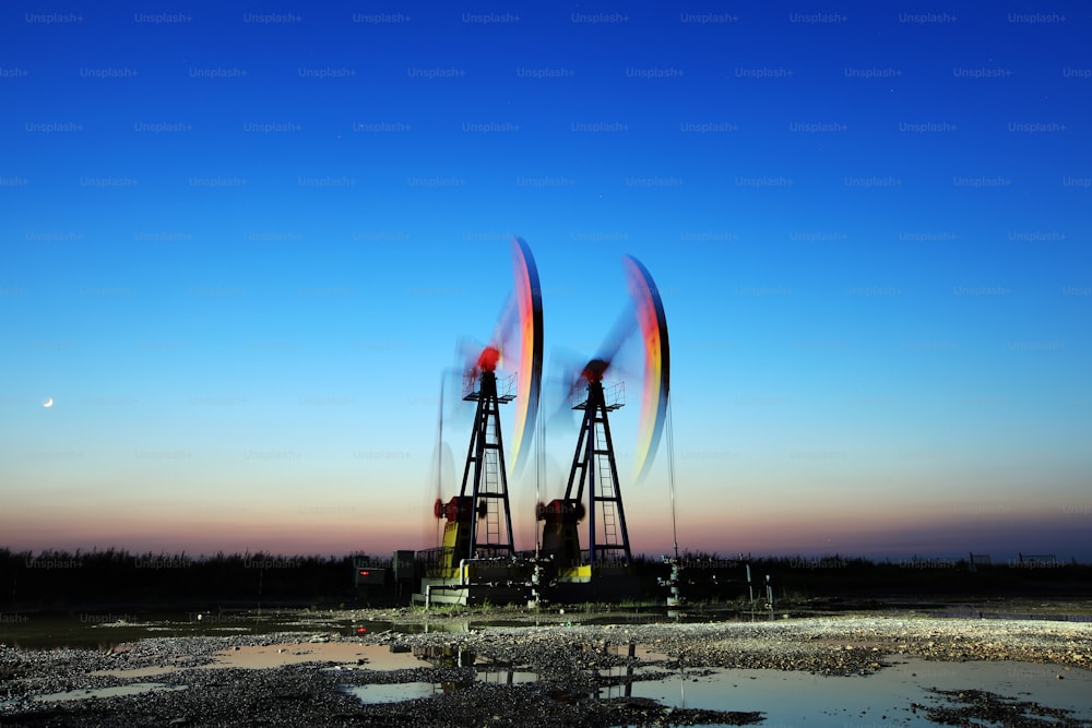 Oil field site, in the evening, oil pumps are running