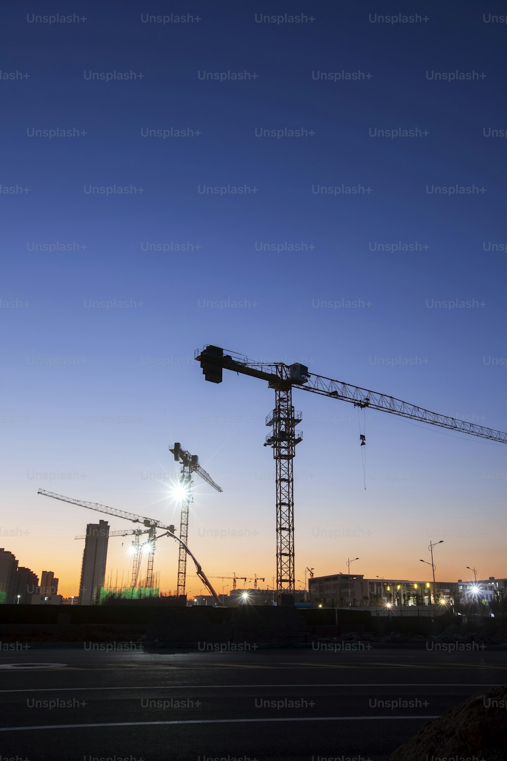 Die Baustelle ist abends, Turmdrehkrane bauen Wohngebäude