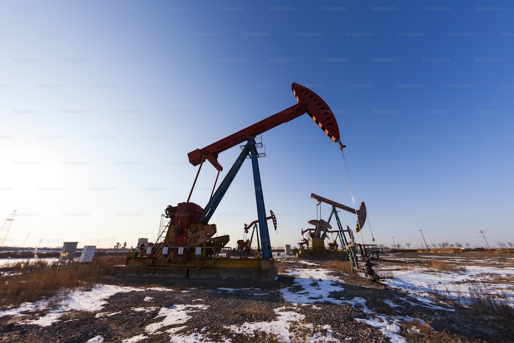 Oil field site, in the evening, oil pumps are running