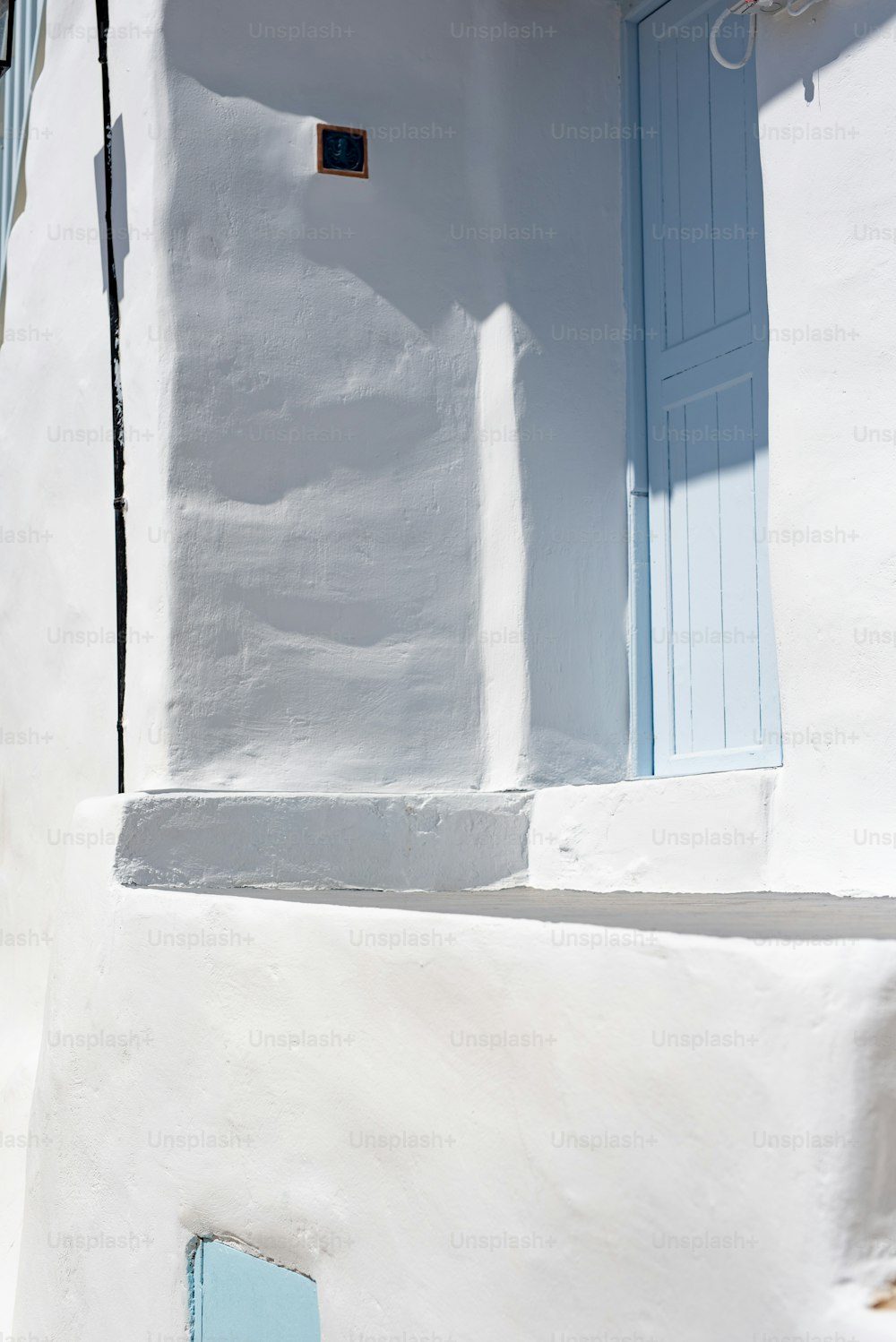 ein weißes Gebäude mit blauer Tür und Fenster
