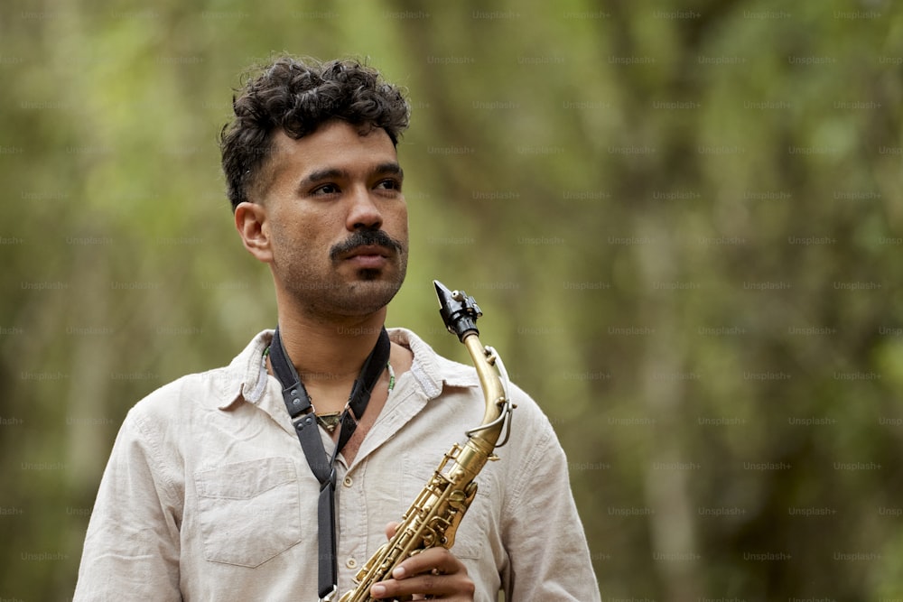 a man holding a saxophone in his right hand