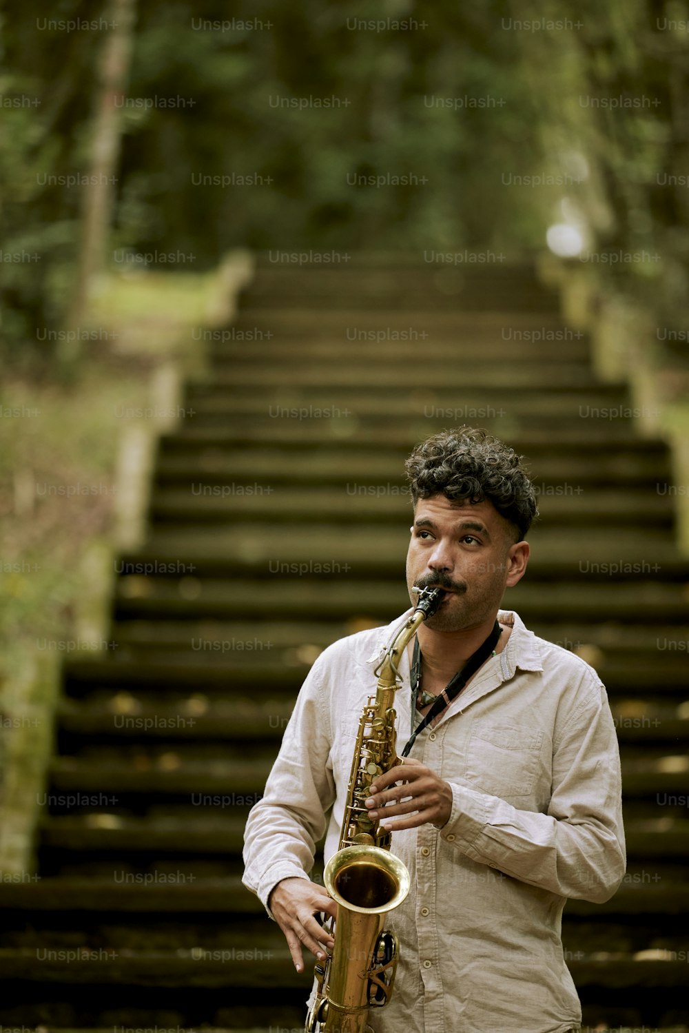 a man playing a saxophone in front of a set of stairs