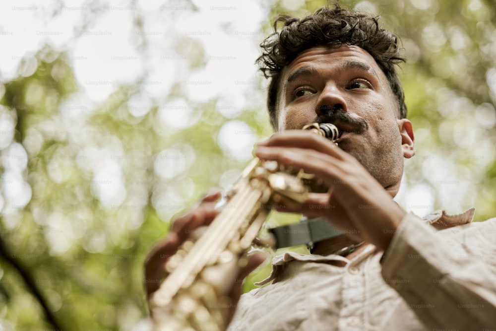Un uomo che suona uno strumento musicale in una foresta