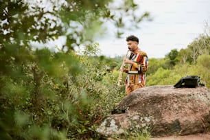 a man standing next to a large rock