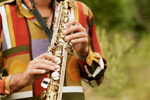 Un hombre sosteniendo un saxofón en sus manos