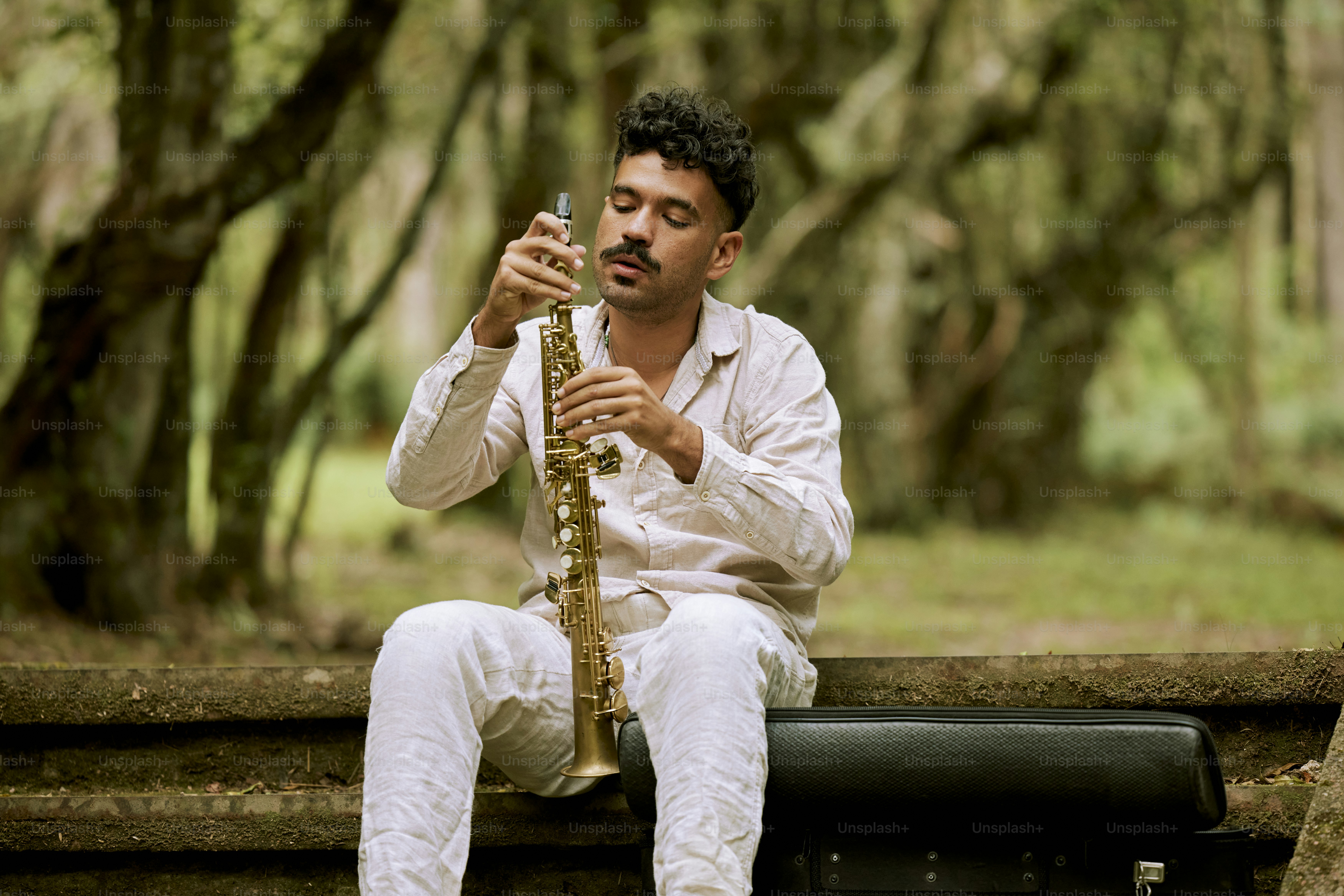 a man sitting on a bench playing a saxophone