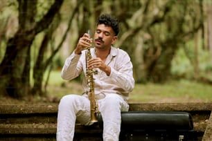 Un hombre sentado en un banco tocando un saxofón