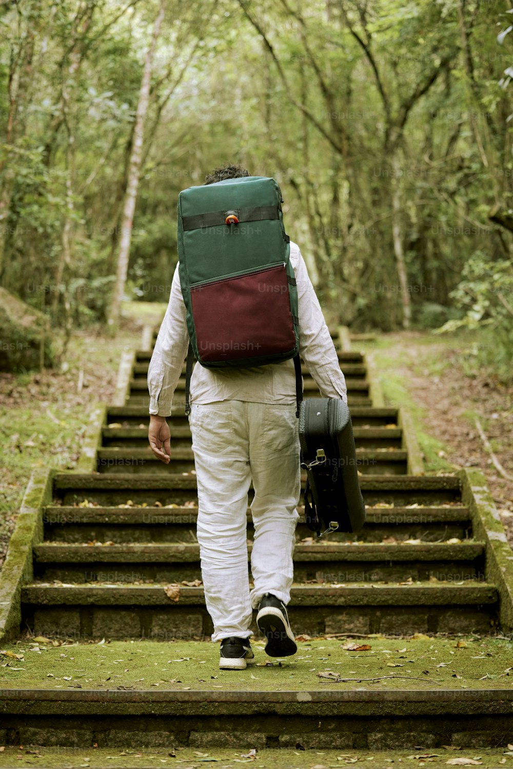 a man with a backpack walking up a set of stairs