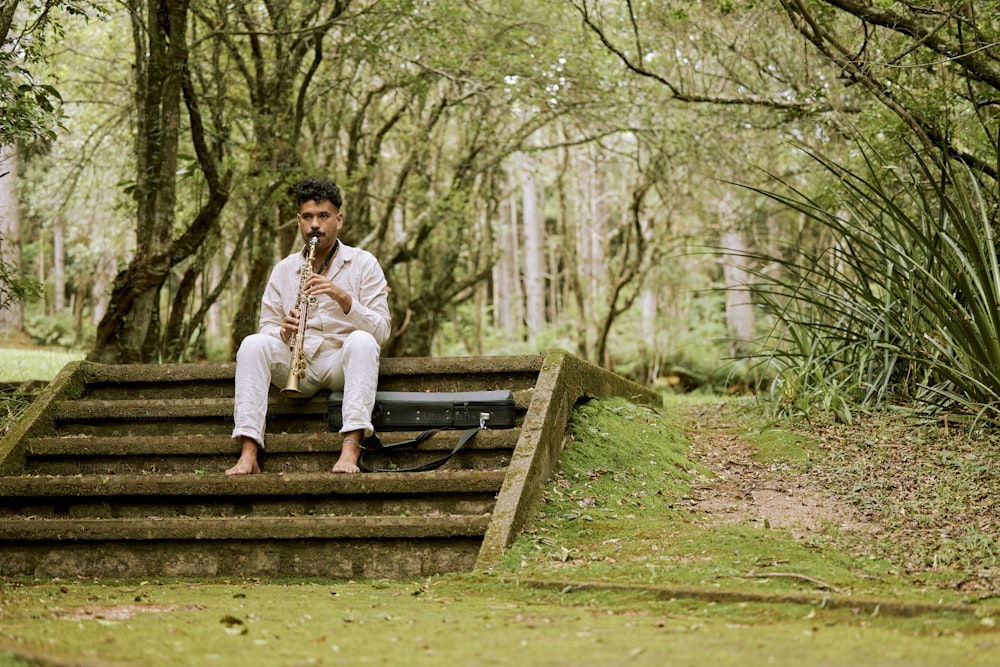 a man sitting on a set of steps in the woods