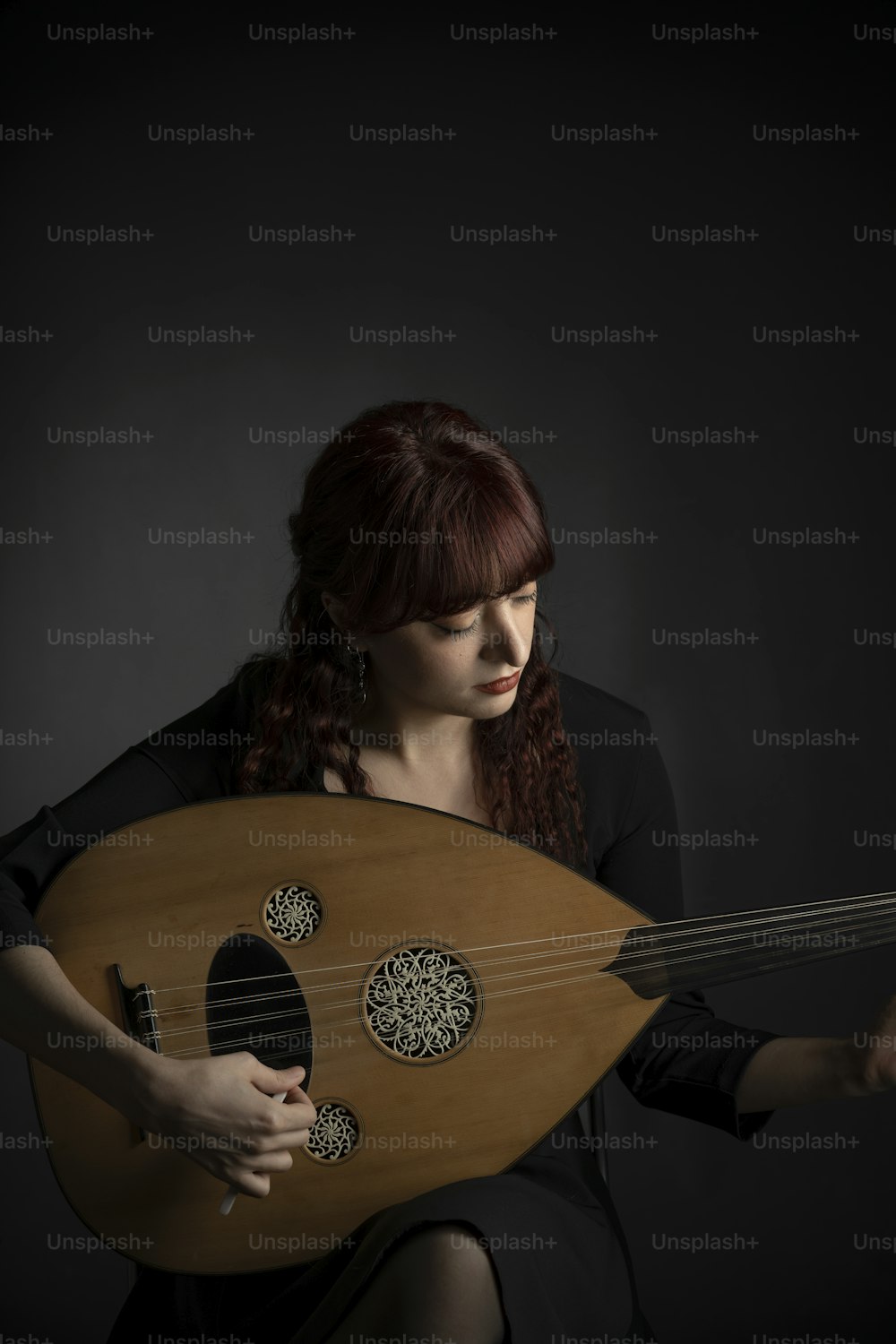 a woman with red hair holding a wooden instrument