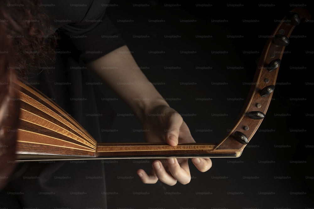 Un primer plano de una persona sosteniendo un instrumento musical