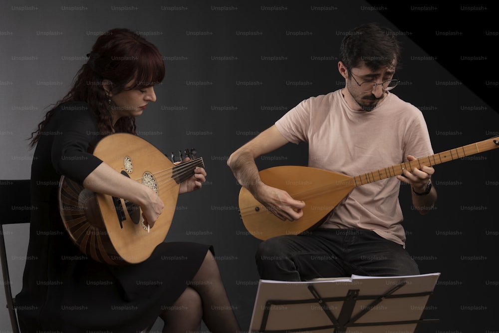 um homem e uma mulher estão tocando guitarras