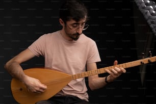 a man with glasses playing a guitar