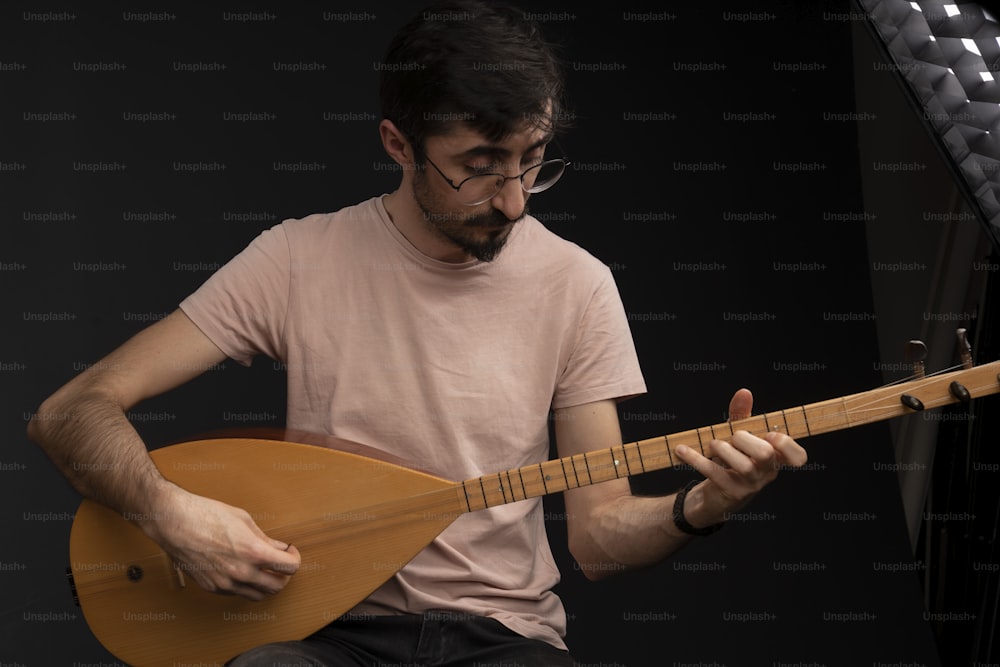 a man with glasses playing a guitar