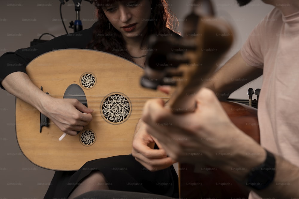 한 남자와 한 여자가 방에서 기타를 연주한다