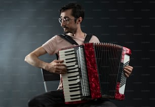 a man is playing an accordion on a dark background
