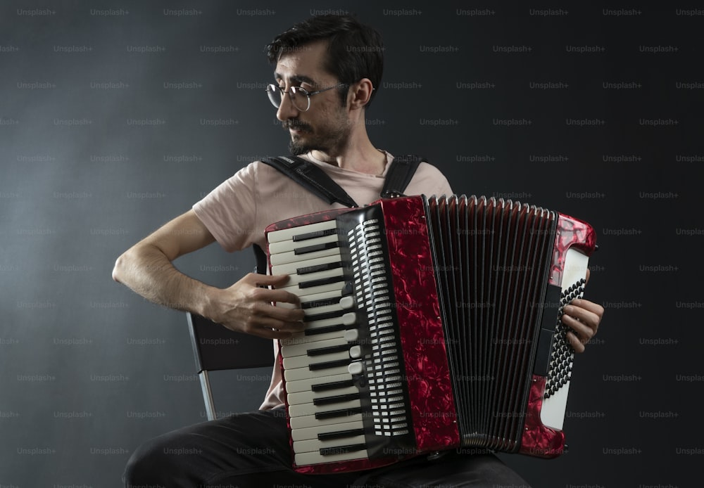 a man is playing an accordion on a dark background