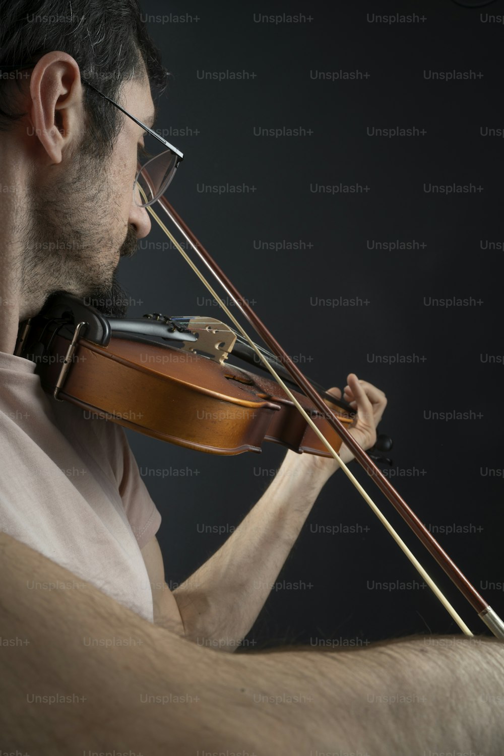Un uomo che suona un violino su uno sfondo nero