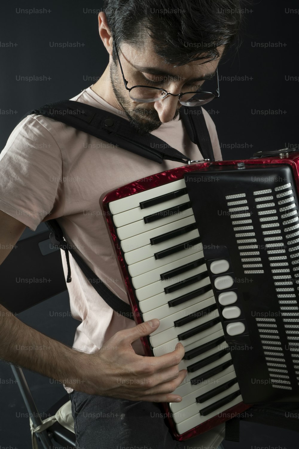 a man holding a red and black accordion