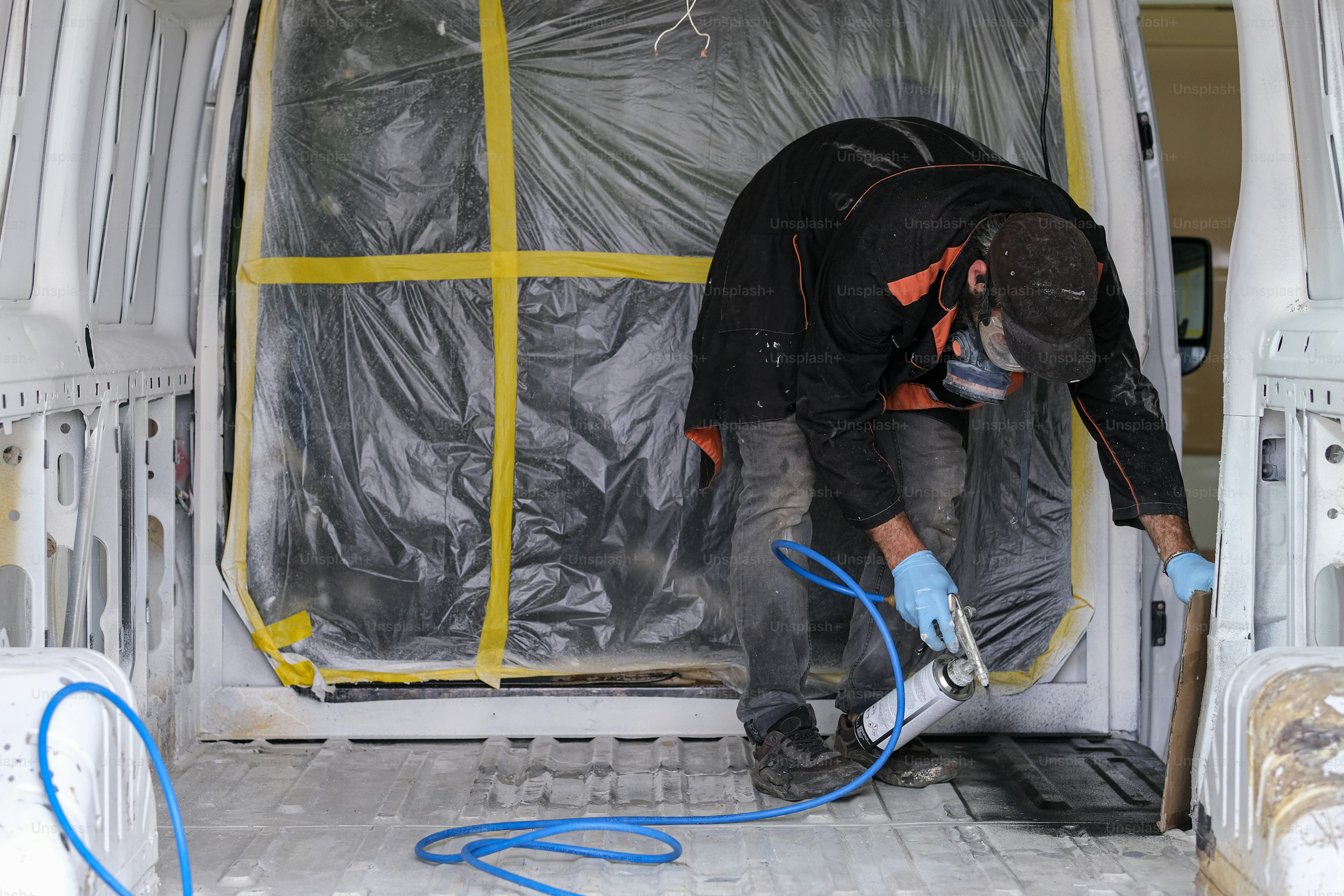a man working on a van with a hose