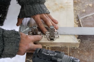 a pair of hands working on a piece of wood