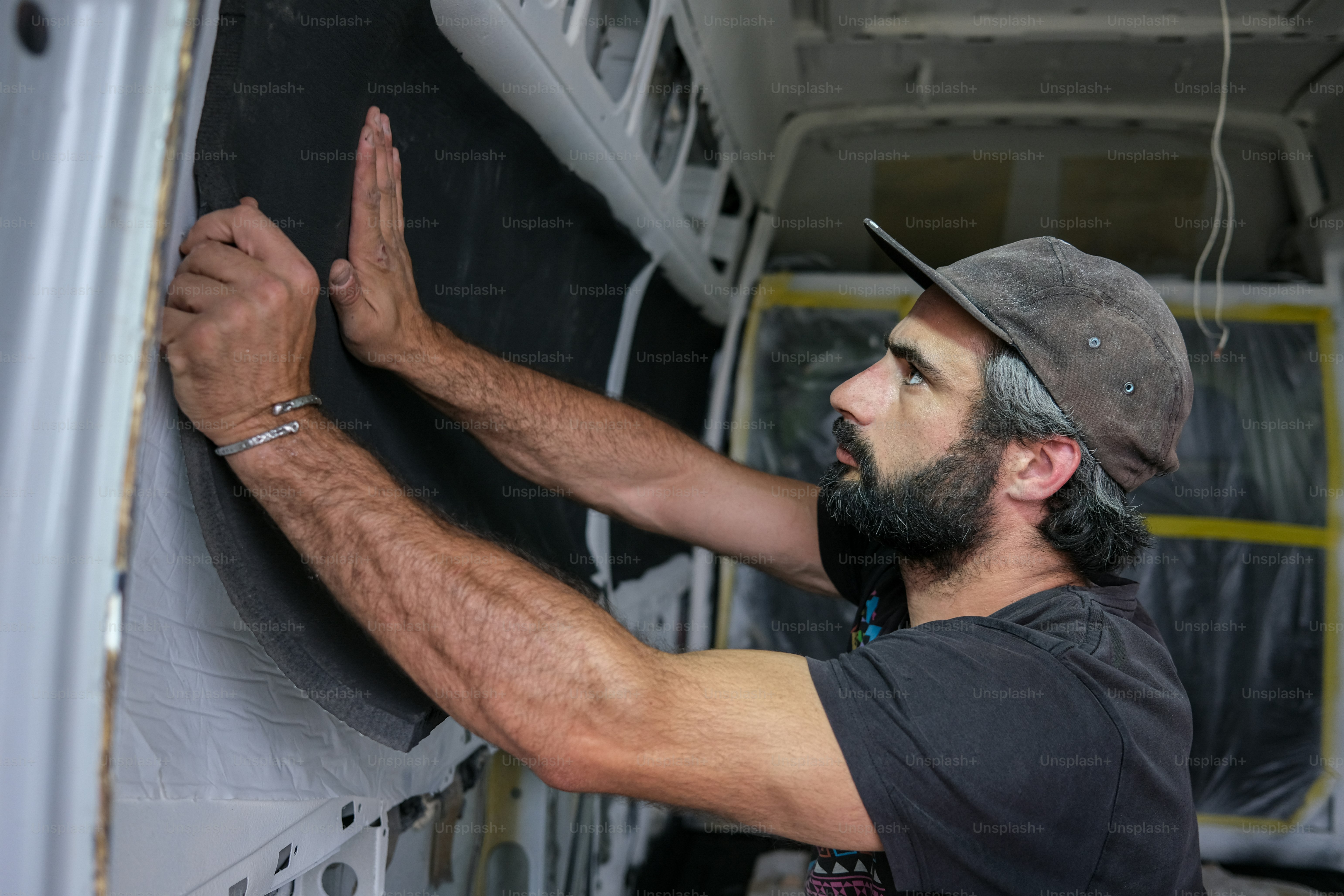 a man in a hat is painting a wall