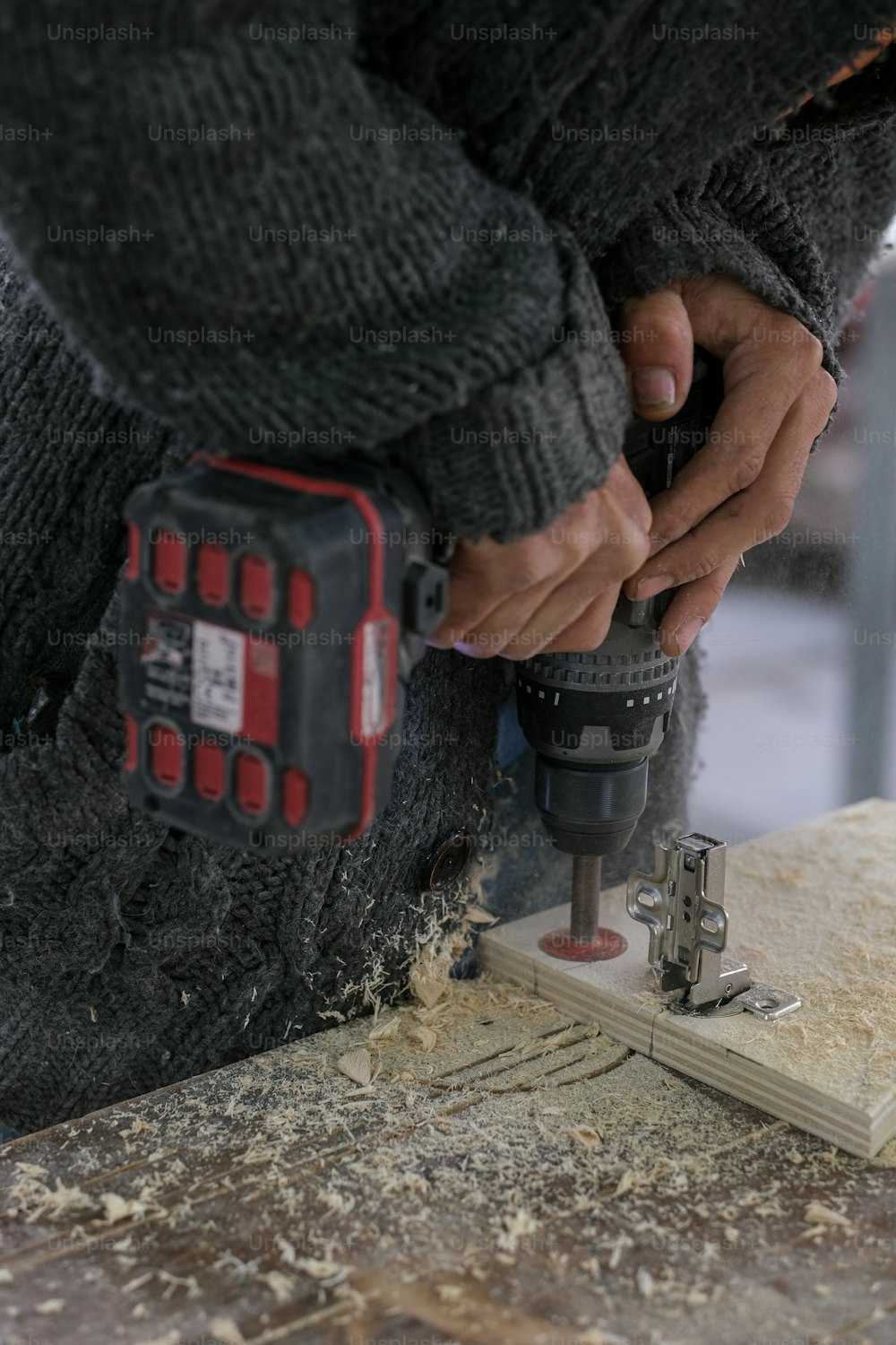 una persona que usa un perforador en un pedazo de madera
