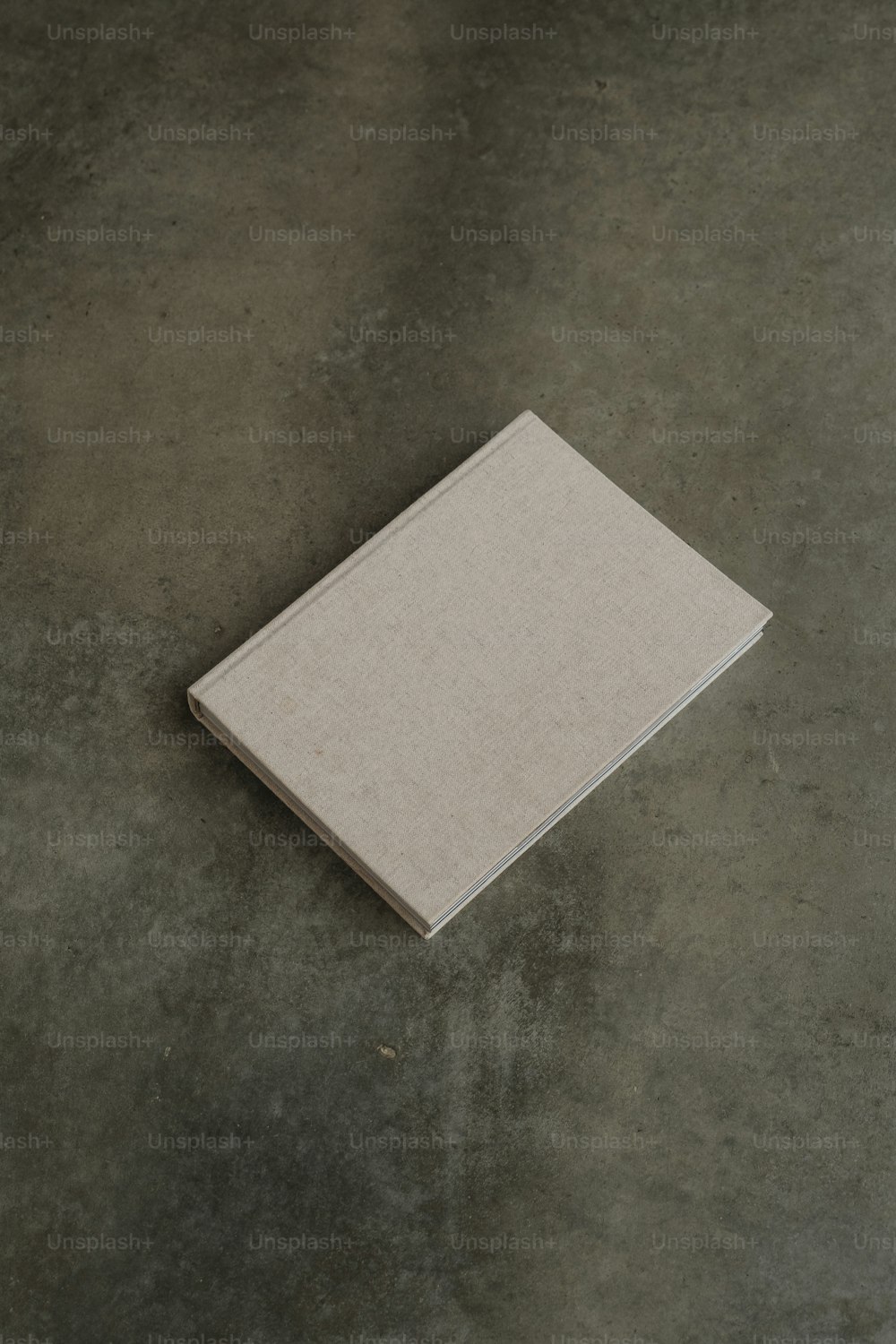 a white book sitting on top of a cement floor