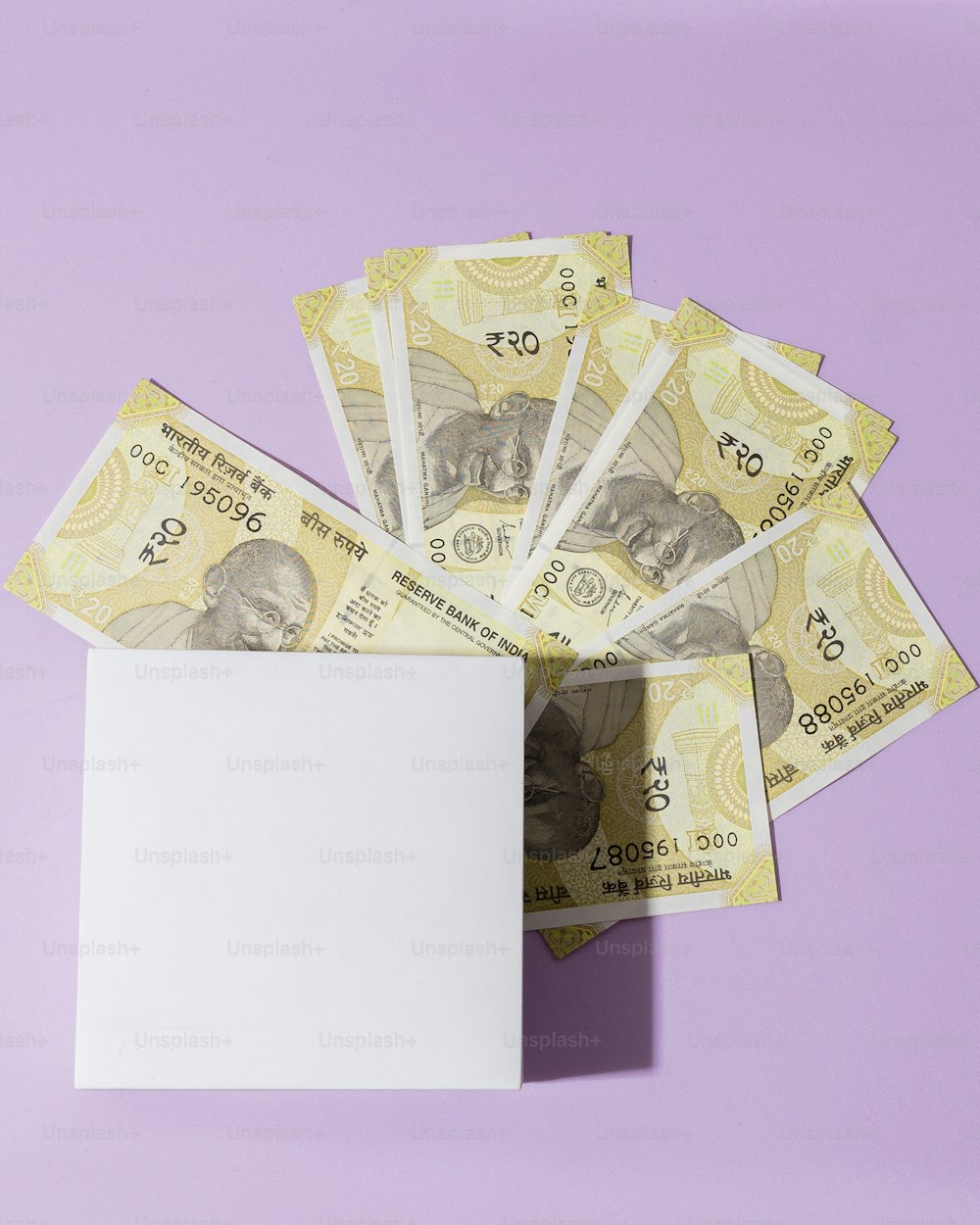 uma pilha de dinheiro sentada em cima de uma superfície roxa