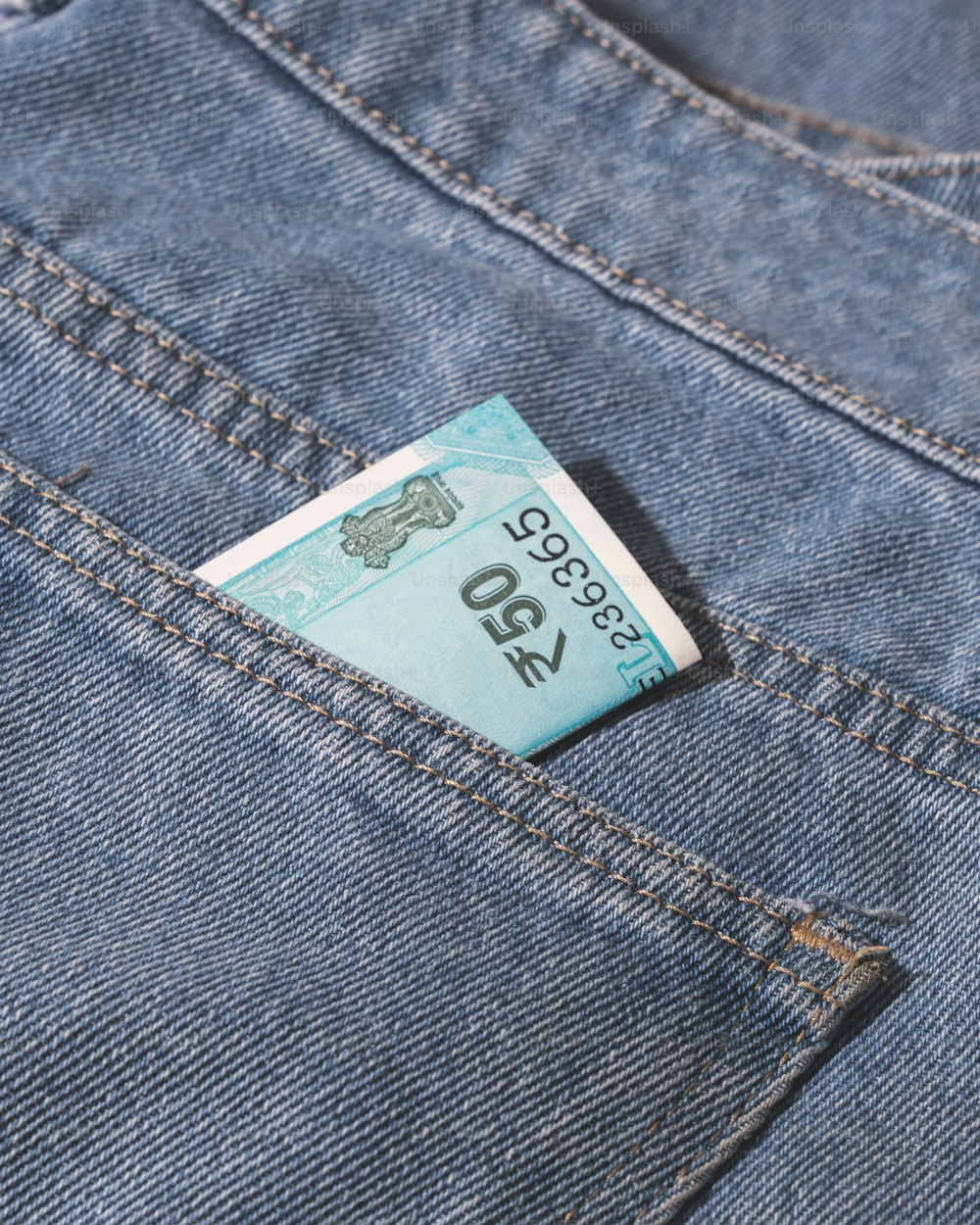 uma nota de dez dólares saindo do bolso de trás de um par de jeans