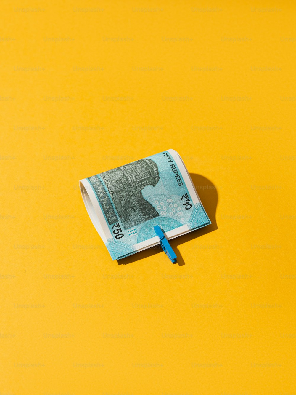 100달러짜리 지폐가 노란 표면에 놓여 있다