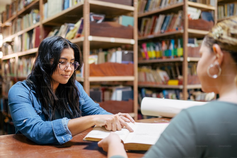 two women sitting at a table in a library