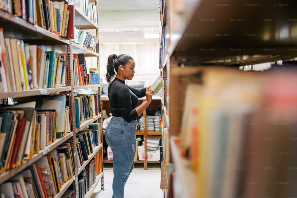 Una mujer leyendo un libro en una biblioteca