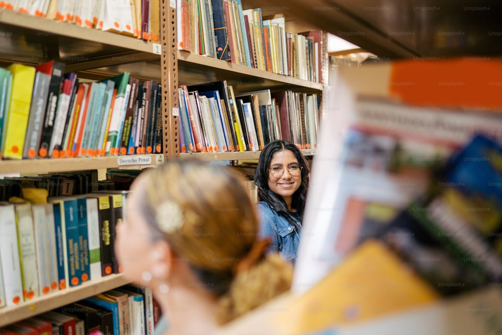 uma mulher em pé na frente de uma estante de livros cheia de livros