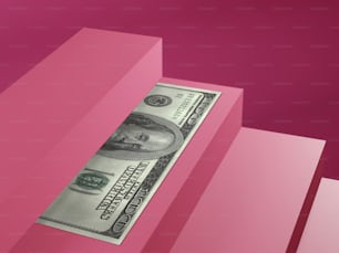 a one dollar bill sticking out of a pink box