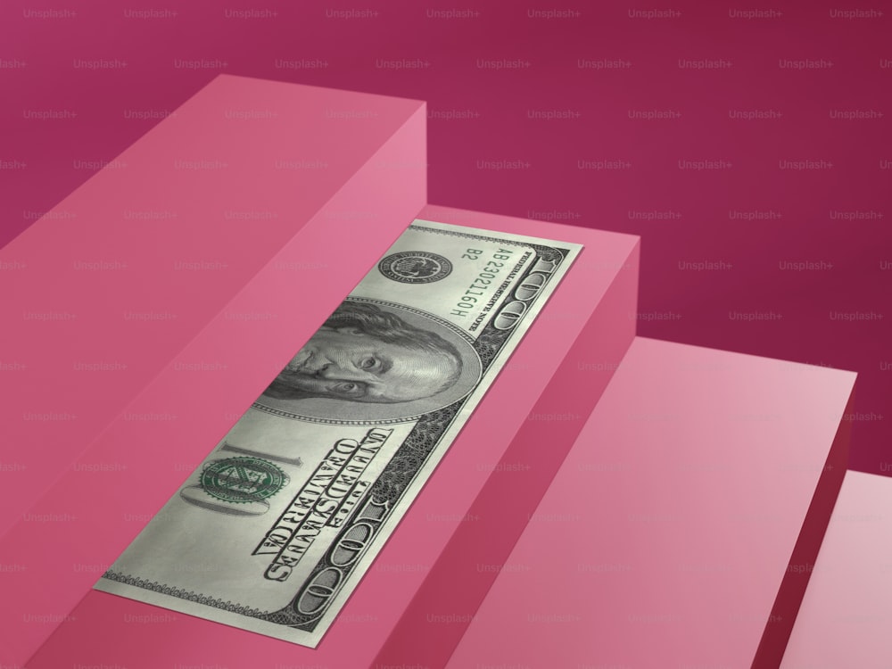 Un billete de un dólar que sobresale de una caja rosa