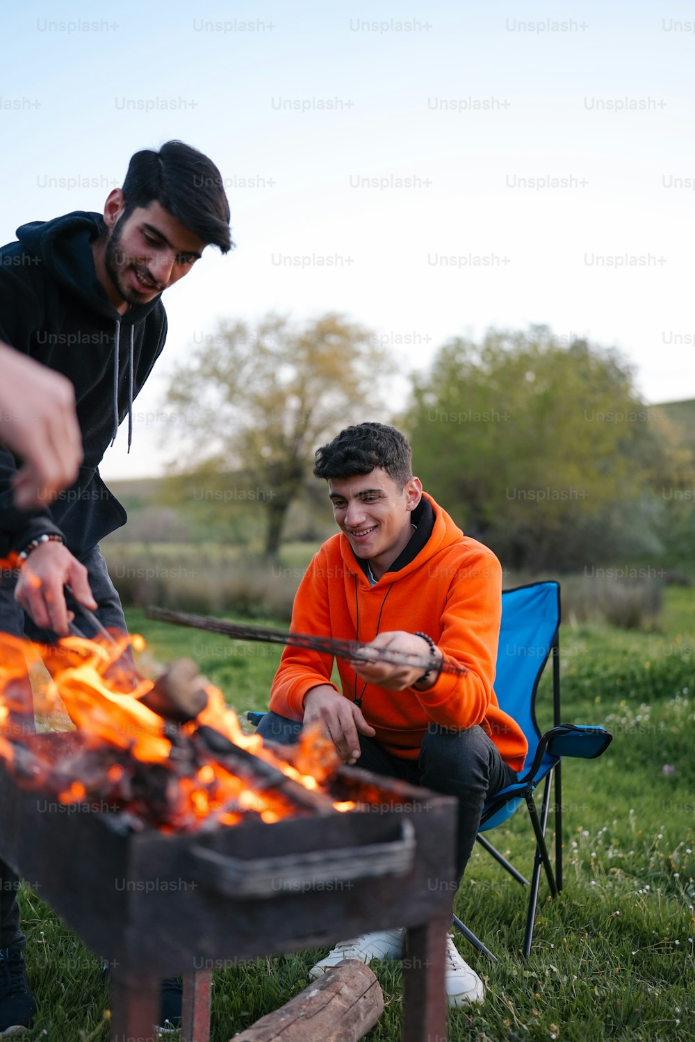 Una coppia di uomini seduti intorno a un pozzo del fuoco