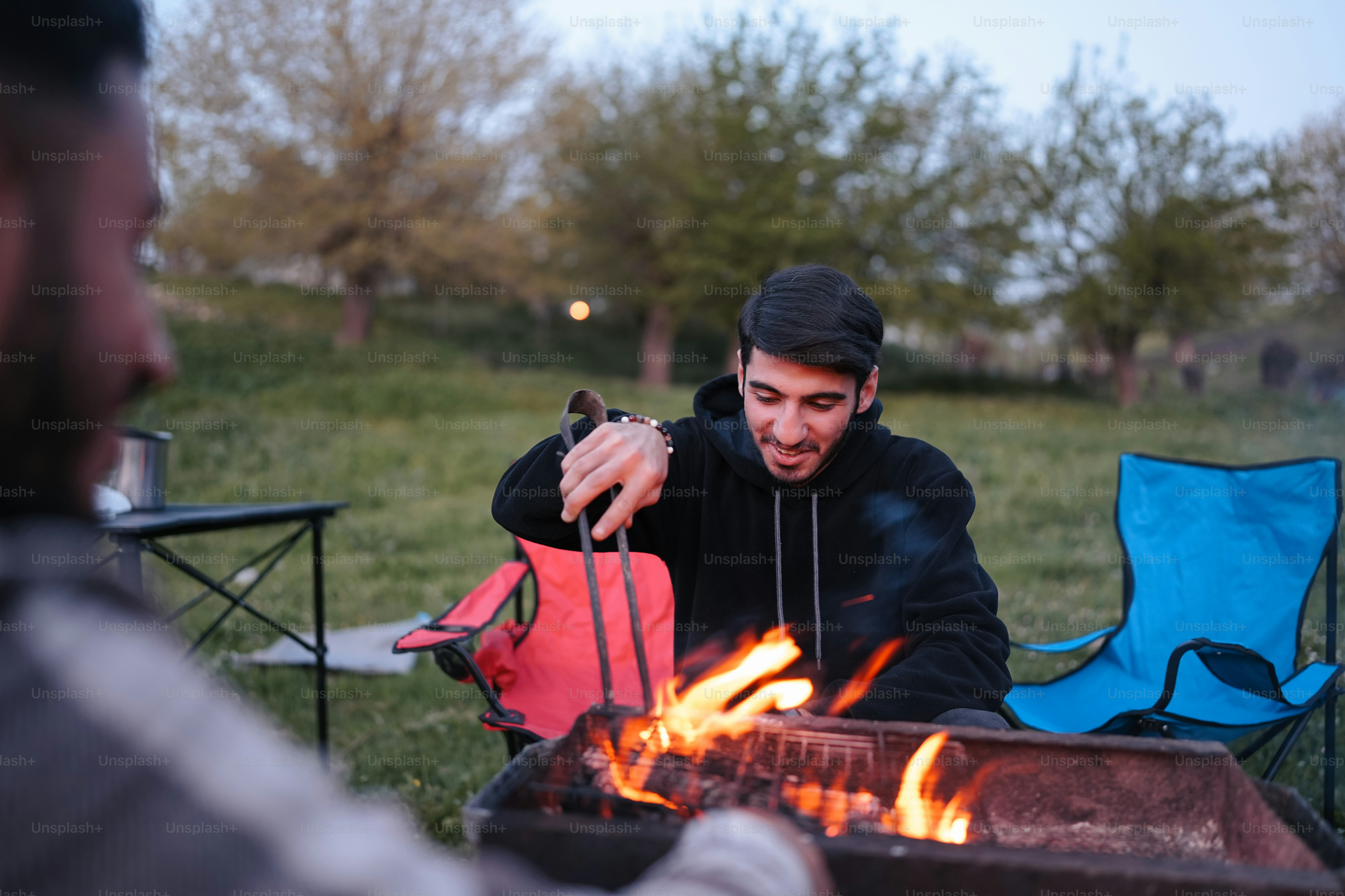 a man sitting in front of a fire pit