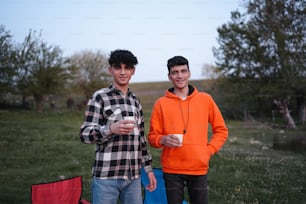 two young men standing next to each other in a field
