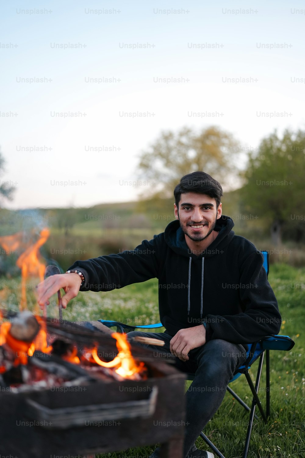 Ein Mann, der auf einem Stuhl neben einem Feuer sitzt