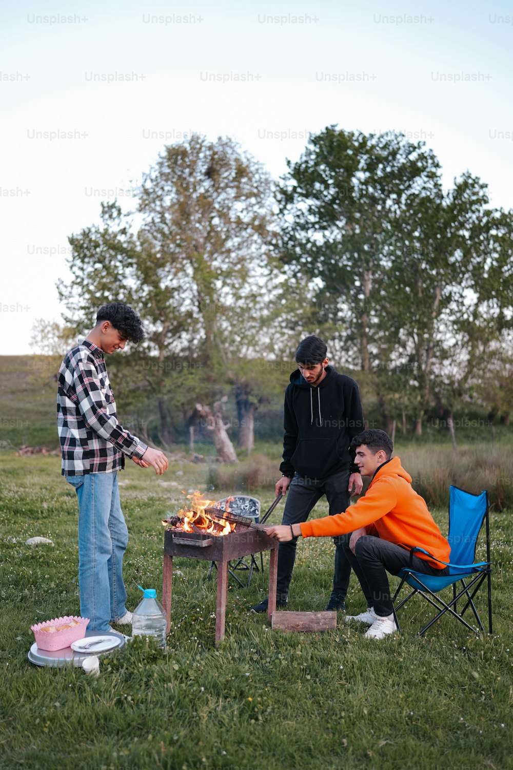 a group of men standing around a fire pit