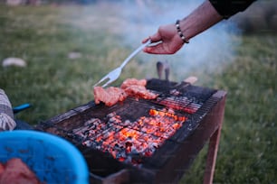 a person is cooking food on a grill