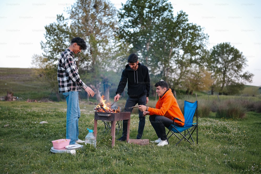 a couple of people standing around a fire