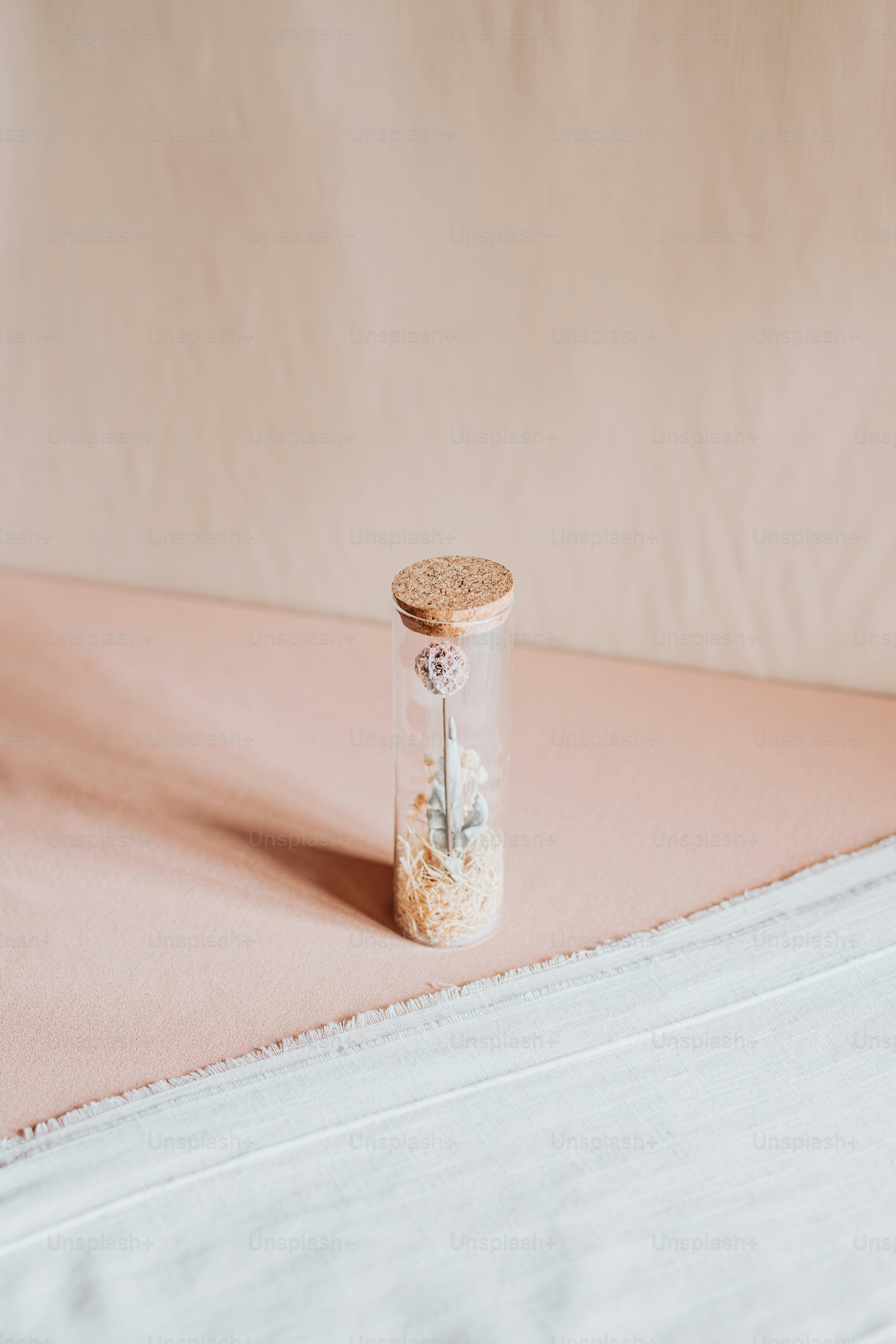 a bottle with a cork lid sitting on top of a bed