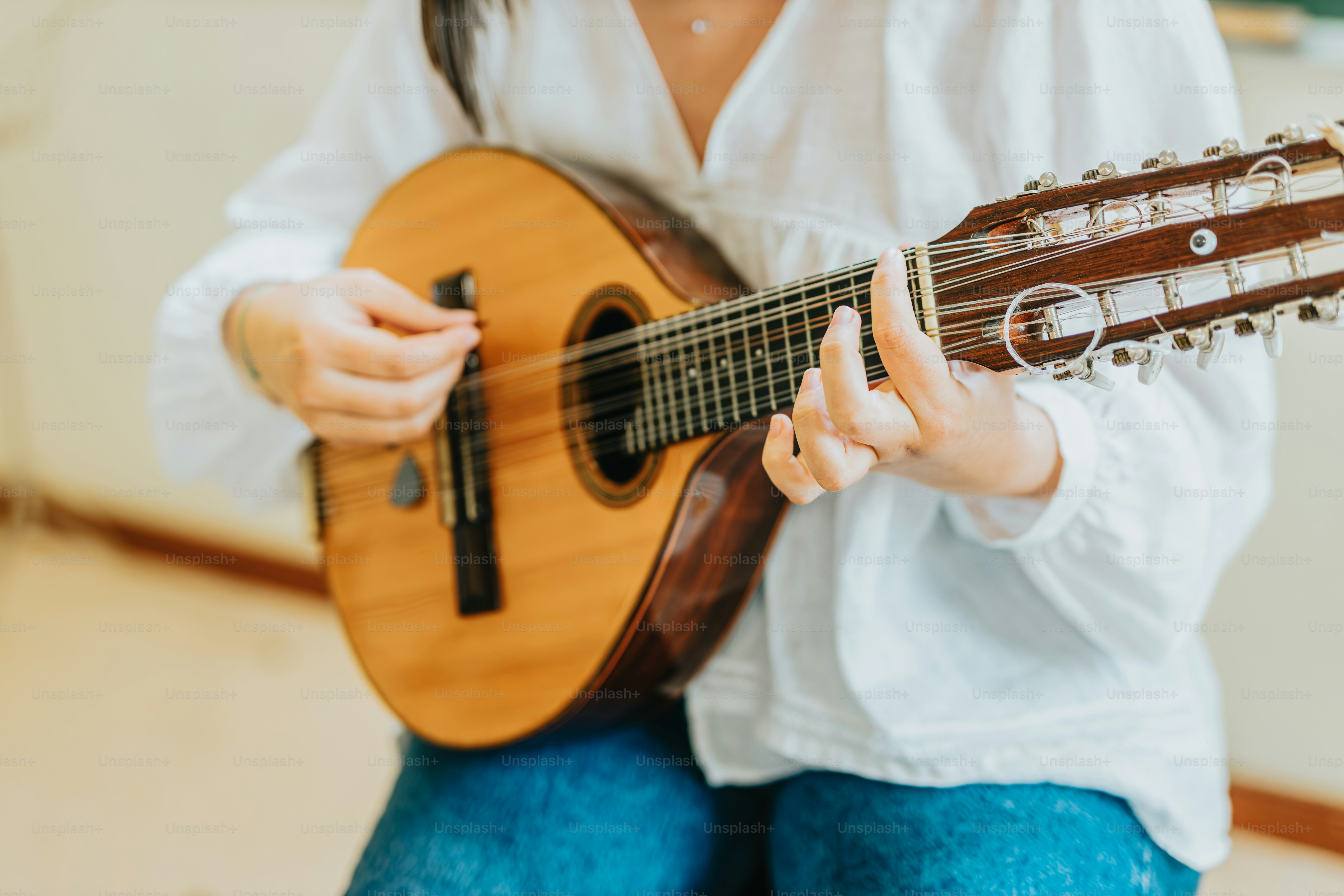 uma mulher sentada em uma cadeira que toca uma guitarra