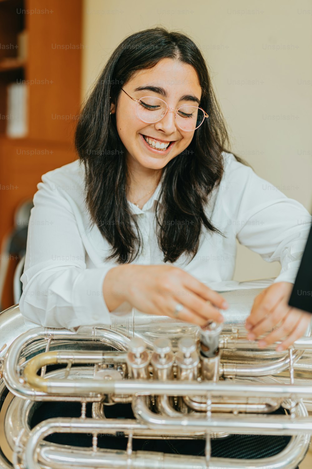 a woman smiles as she plays a musical instrument