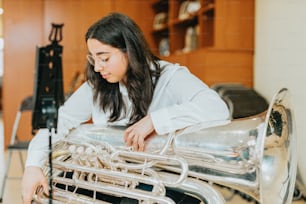 a woman in a white shirt is playing a musical instrument